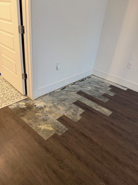 Bedroom flooring torn up next to the bathroom door during the water leak repairs