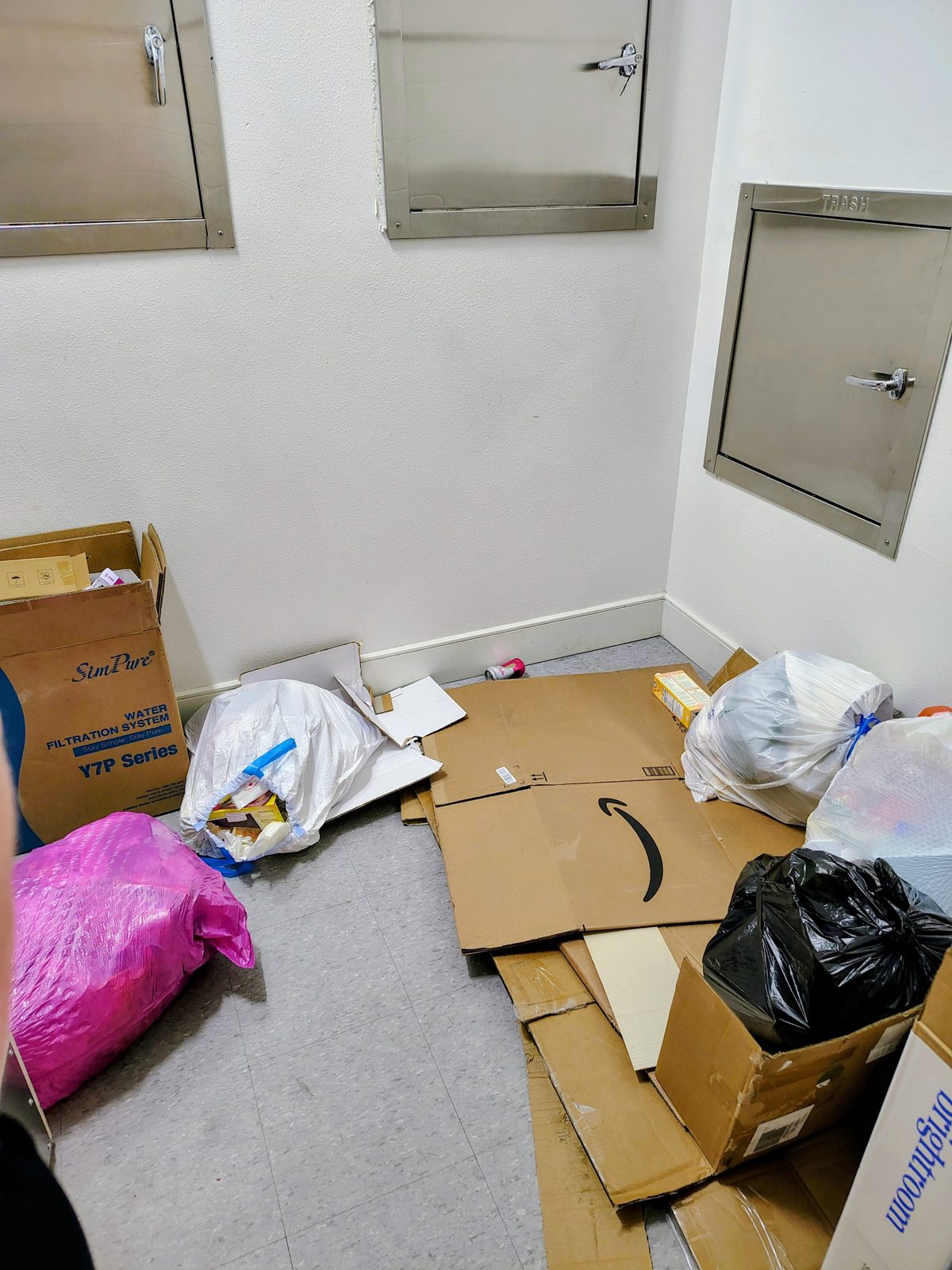 Trash bags and boxes piled on the floor of a trash room at The Beverly, July 27, 2026